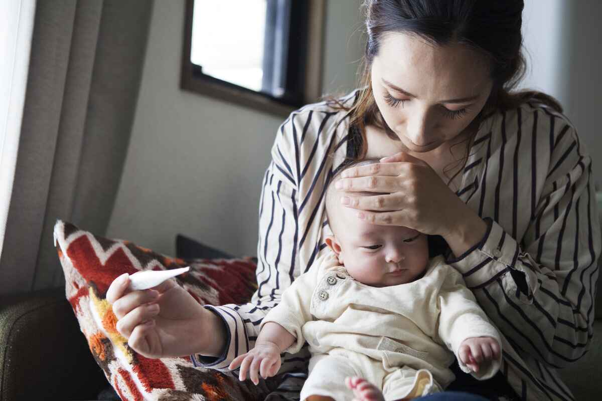 Mother worried about RSV takes her baby's temperature