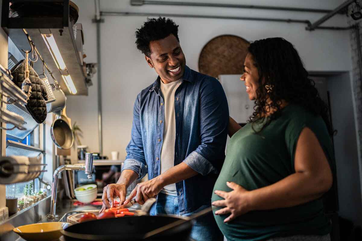 Couple cooks a healthy meal together during pregnancy