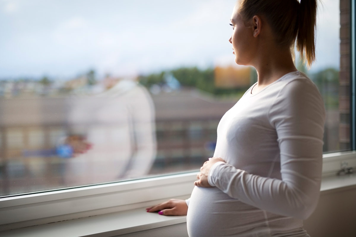 Pregnant Woman Looking Out a Window