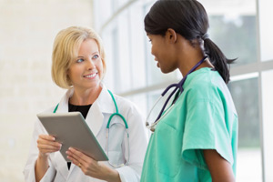 Doctor holding tablet speaking with Nurse