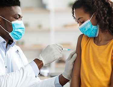 young male doctor giving young female a vaccine